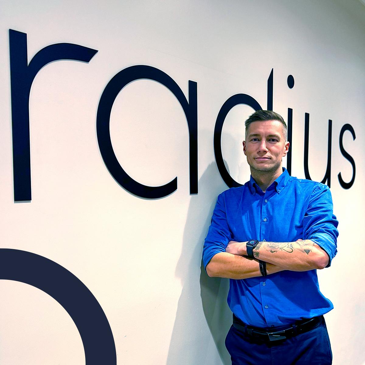 Sales manager posing with Radius logo