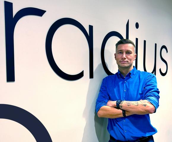 Sales manager posing with Radius logo